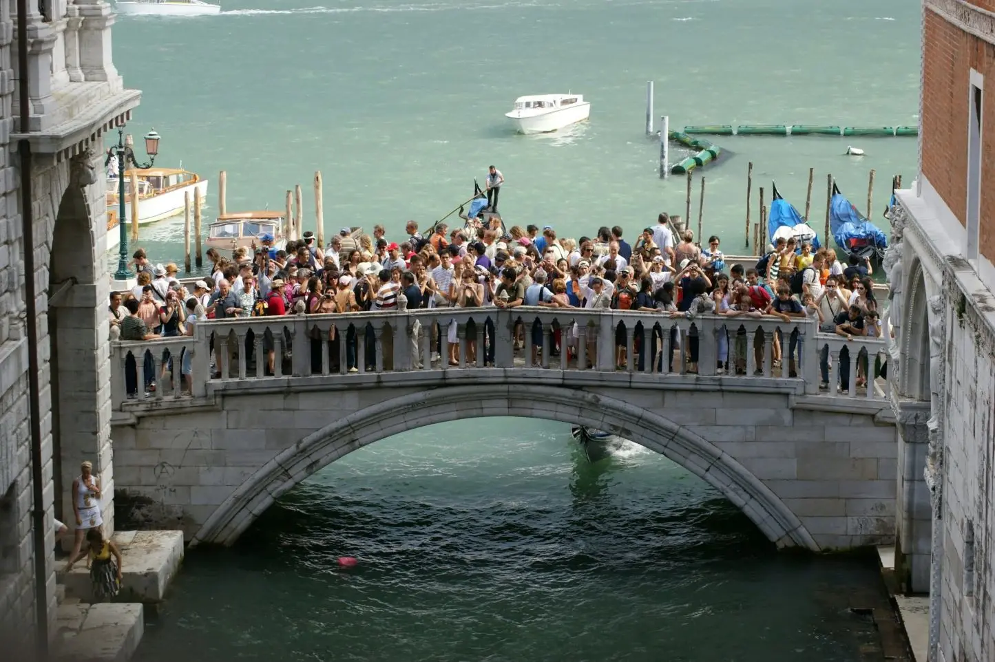 An old bridge crowded of tourists due to overtourism in Venice